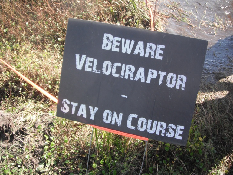 Sign that says 'Beware velociraptor - Stay on course'