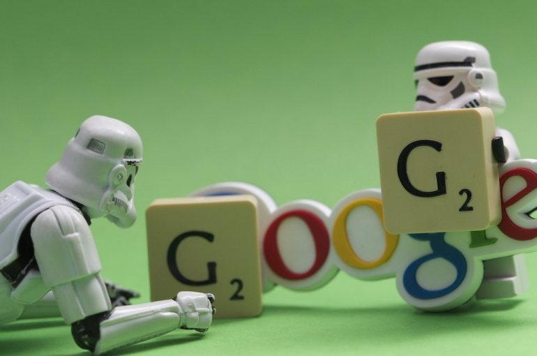 Two Stormtrooper figures placing scrabble G letters over the Google logo