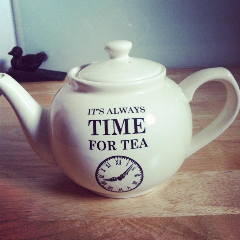 Tea pot with words on it that say 'It's always time for tea' and a clock graphic underneath them