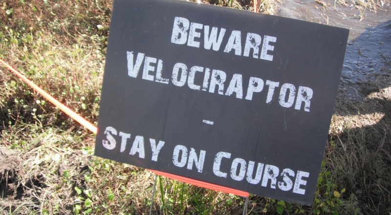 Sign that says 'Beware velociraptor - Stay on course'