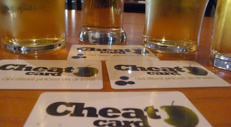 Drinks on a table with coasters saying 'Cheat card' on them