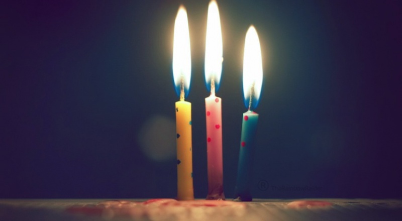 Three birthday candles burning