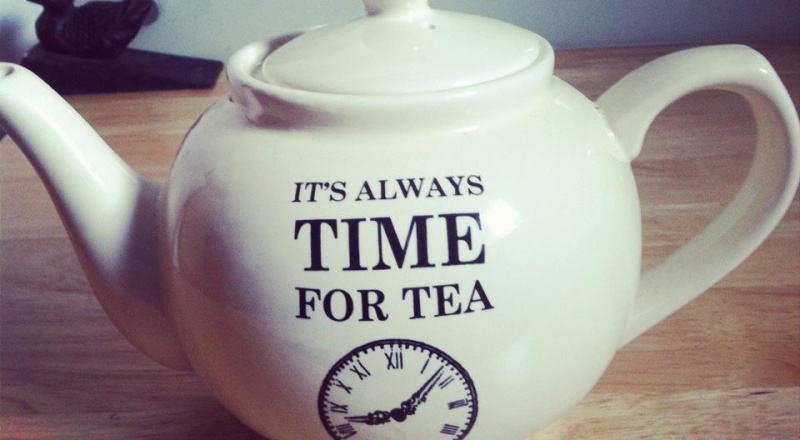 Tea pot with words on it that say 'It's always time for tea' and a clock graphic underneath them